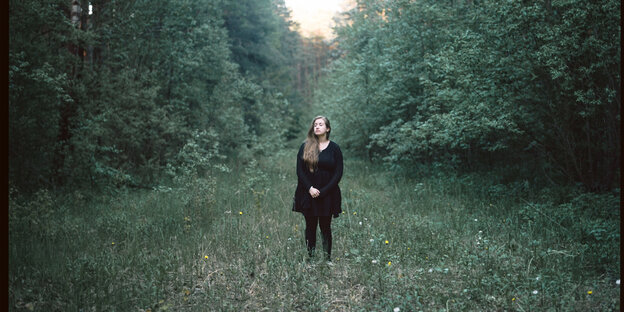 Eine Frau steht in einem Wald Eine Frau steht in einem Wald