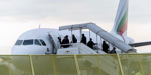 Menschen besteigen über eine Gangway ein Flugzeug Menschen besteigen über eine Gangway ein Flugzeug
