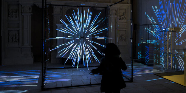Die Silhouette einer Person vor einer Lichtinstallation Die Silhouette einer Person vor einer Lichtinstallation