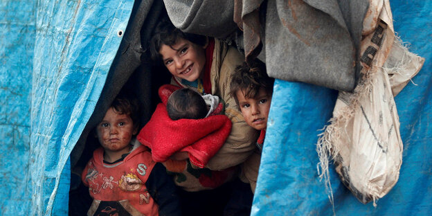 Syrische Kinder schauen aus einem Zelt nahe der Grenze zur Türkei Syrische Kinder schauen aus einem Zelt nahe der Grenze zur Türkei