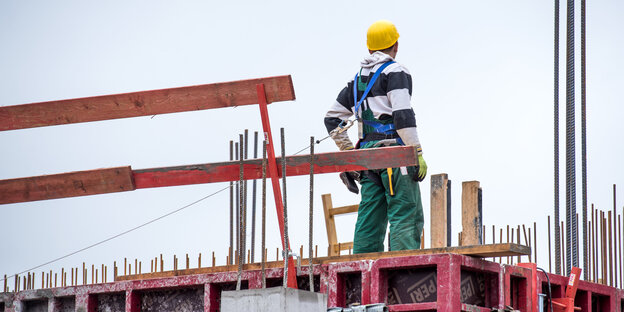Ein Bauarbeiter steht auf einer Baustelle Ein Bauarbeiter steht auf einer Baustelle