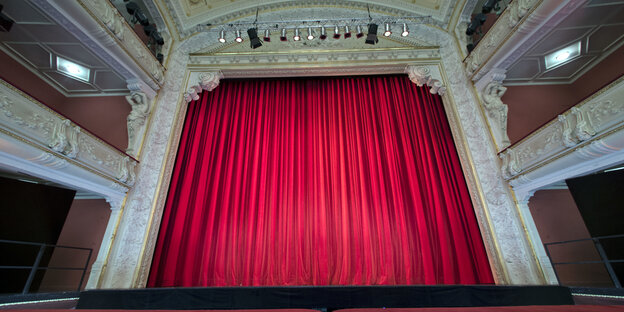 Die Bühne des Mecklenburgischen Staatstheaters ist mit einem roten Vorhang vollständig verhüllt. Die Bühne des Mecklenburgischen Staatstheaters ist mit einem roten Vorhang vollständig verhüllt.