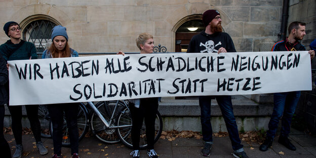 Fünf junge Leute stehen vor der Mauer eines alten Gebäudes und tragen ein Transparent, auf dem steht: "Wir haben alle schädliche Neigungen. Solidarität statt Hetze." Fünf junge Leute stehen vor der Mauer eines alten Gebäudes und tragen ein Transparent, auf dem steht: "Wir haben alle schädliche Neigungen. Solidarität statt Hetze."