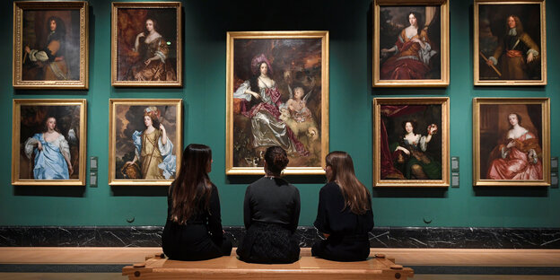 Drei Frauen sitzen vor mehreren Gemälden in einem Museum Drei Frauen sitzen vor mehreren Gemälden in einem Museum