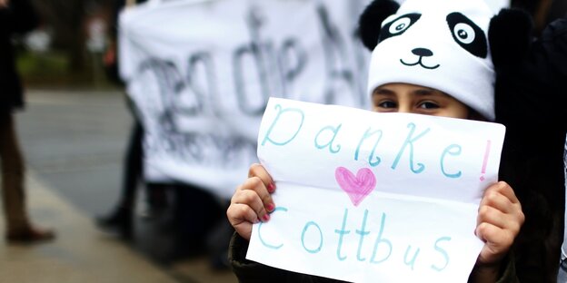 Ein Kind mit einem Schild, auf dem „Danke Cottbus“ steht Ein Kind mit einem Schild, auf dem „Danke Cottbus“ steht