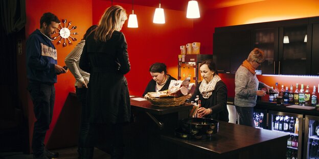 DFrauen und Männer sitzen und stehen in einer Bar DFrauen und Männer sitzen und stehen in einer Bar