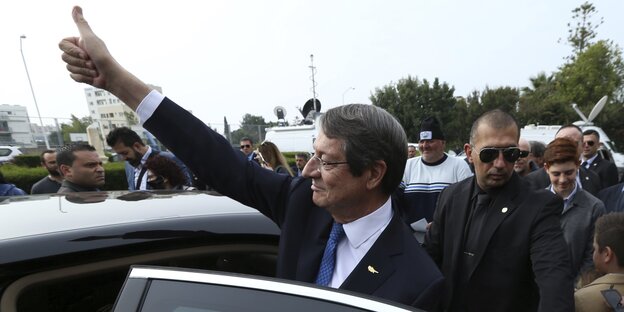 Nikos Anastasiades steht an einem Auto und streckt der Menge einen erhobenen Daumen entgegen Nikos Anastasiades steht an einem Auto und streckt der Menge einen erhobenen Daumen entgegen
