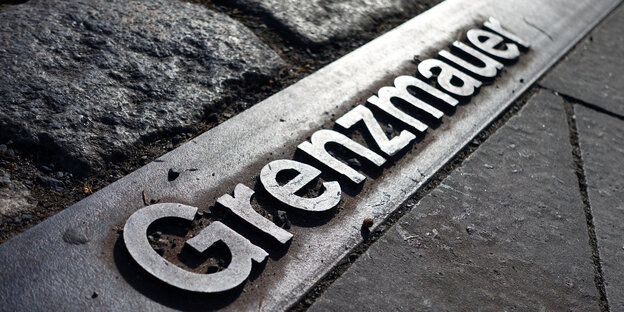 Grenzmauer steht auf einer Metallplatte Grenzmauer steht auf einer Metallplatte