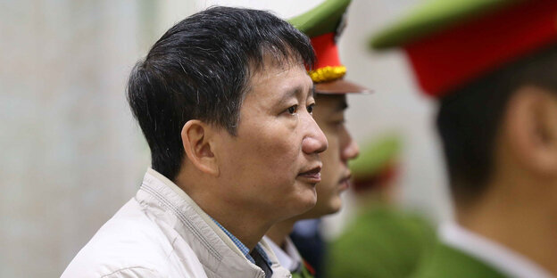 Trinh Xuan Thanh steht neben Polizisten Trinh Xuan Thanh steht neben Polizisten