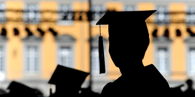 Absolventen mit den typischen eckigen Akademikerhüten Absolventen mit den typischen eckigen Akademikerhüten