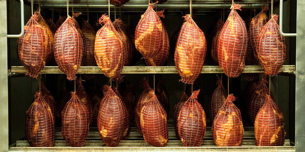 Schweinefleisch hängt in der Räucherkammer Schweinefleisch hängt in der Räucherkammer
