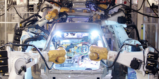 Roboter bauen Autos am Fließband zusammen Roboter bauen Autos am Fließband zusammen