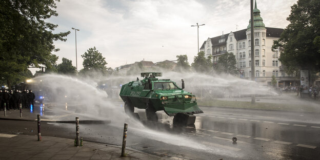 Ein Räumfahrzeug der Polizei schiebt flaniert von zwei Wasserwerfern eine Mülltonne von einer Straße in Hamburg. Ein Räumfahrzeug der Polizei schiebt flaniert von zwei Wasserwerfern eine Mülltonne von einer Straße in Hamburg.