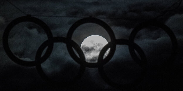 Der Mond ist durch die Ringe am Berliner olympiastadion zu sehen