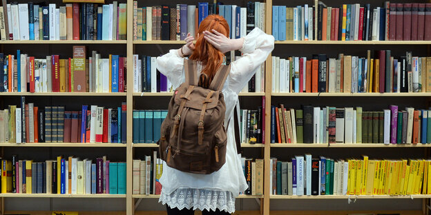Eine Frau steht vor einem Buchregal Eine Frau steht vor einem Buchregal