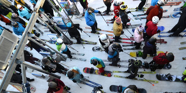 Wintersportler stehen am Lift an Wintersportler stehen am Lift an