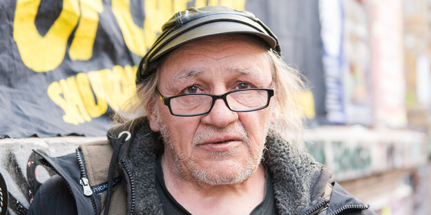 Ein Mann steht vor einer Mauer Ein Mann steht vor einer Mauer