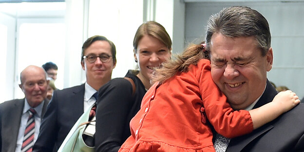 Sigmar Gabriel hält ein Kind auf dem Arm und lacht Sigmar Gabriel hält ein Kind auf dem Arm und lacht