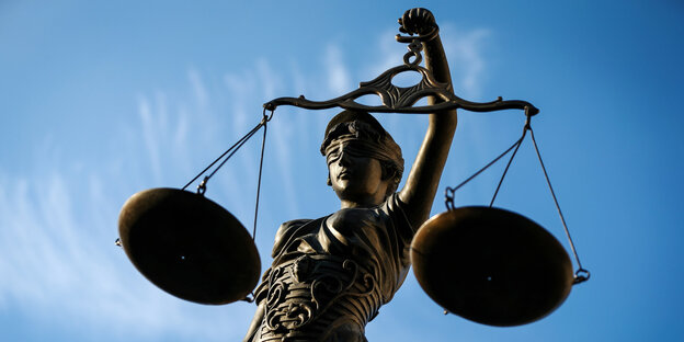 Eine Justizia-Figur vor blauem Himmel Eine Justizia-Figur vor blauem Himmel
