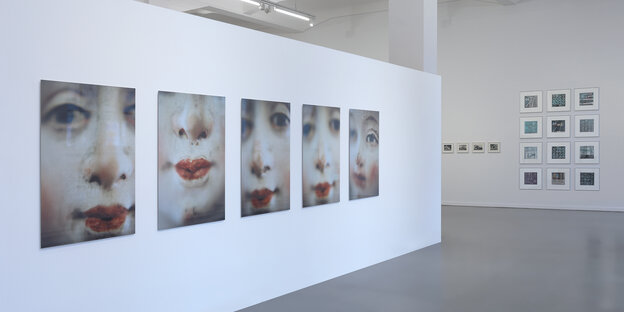 Eine Wand mit fünf Portraitfotos von einer Frau mit rot geschminkten Lippen. Eine Wand mit fünf Portraitfotos von einer Frau mit rot geschminkten Lippen.