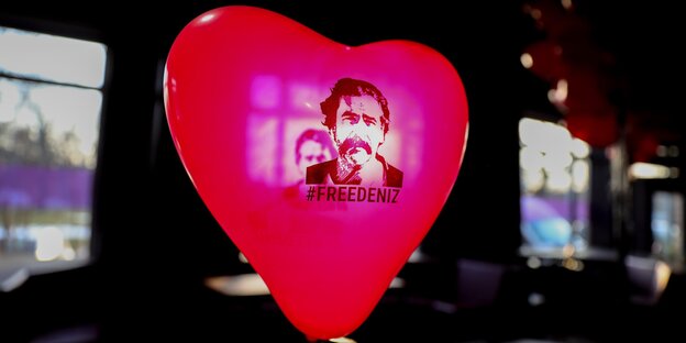 Ein roter Luftballon in Herzform mit dem Konterfei von Deniz Yücel Ein roter Luftballon in Herzform mit dem Konterfei von Deniz Yücel