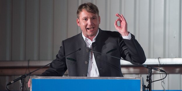 Ein Mann hinter einem Rednerpult Ein Mann hinter einem Rednerpult