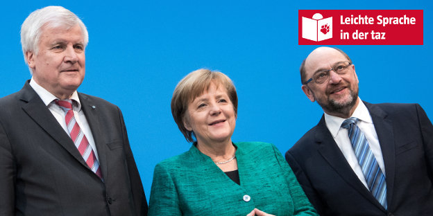 Zwei Männer und eine Frau im Anzug stehen vor einer blauen Wand Zwei Männer und eine Frau im Anzug stehen vor einer blauen Wand