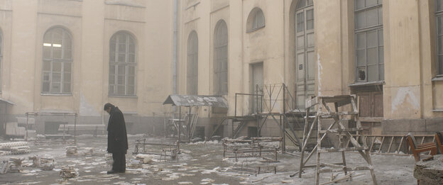 Fassade im Nebel, Papier und Schnee auf dem Boden, ein einsamer Mann