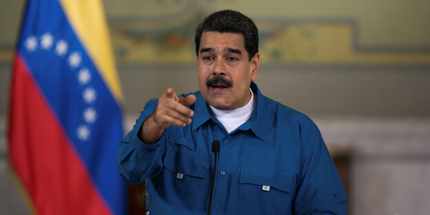 Präsident Nicolás Maduro neben der venezolanischen Flagge Präsident Nicolás Maduro neben der venezolanischen Flagge