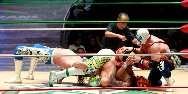 Vier Wrestler und ein Schiedsrichter im Ring Vier Wrestler und ein Schiedsrichter im Ring
