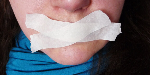 Der Mund einer Frau ist mit weißem Tape zugeklebt Der Mund einer Frau ist mit weißem Tape zugeklebt