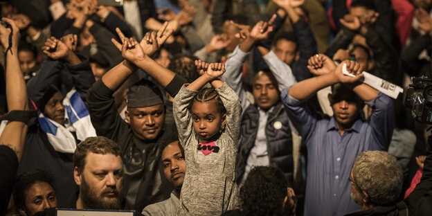 Flüchtlinge heben die Hände wie mit Handschellen gefesselt Flüchtlinge heben die Hände wie mit Handschellen gefesselt