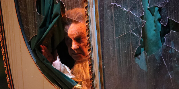 Ein Schauspieler guckt aus dem Fenster einer Sänfte Ein Schauspieler guckt aus dem Fenster einer Sänfte