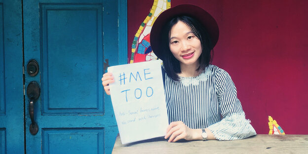 Eine junge Frau hält ein Blatt Papier hoch, auf dem "Me Too" steht Eine junge Frau hält ein Blatt Papier hoch, auf dem "Me Too" steht