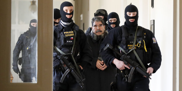 Polizisten eskortieren den syrisch-kurdischen Politiker Salih Muslim (M) in ein Gericht. Polizisten eskortieren den syrisch-kurdischen Politiker Salih Muslim (M) in ein Gericht.