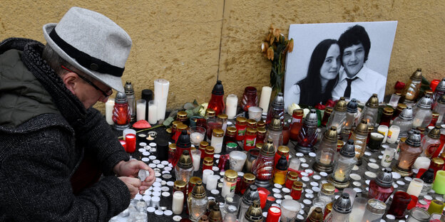 Ein Mann zündet eine Kerze am Foto Jan Kuciaks und seiner Freundin an Ein Mann zündet eine Kerze am Foto Jan Kuciaks und seiner Freundin an