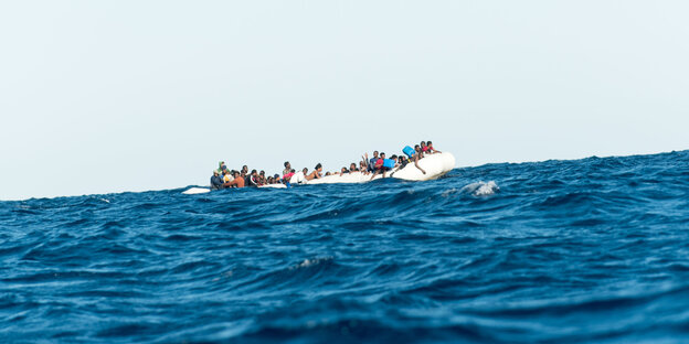 Ein Flüchtlingsboot treibt auf offenem Meer Ein Flüchtlingsboot treibt auf offenem Meer
