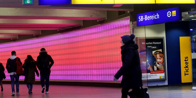 Essen: Nutzer des öffentlichen Nahverkehrs gehen durch einen pinkfarben erleuchteten Tunnel zu den Bussen und Bahnen. Essen: Nutzer des öffentlichen Nahverkehrs gehen durch einen pinkfarben erleuchteten Tunnel zu den Bussen und Bahnen.