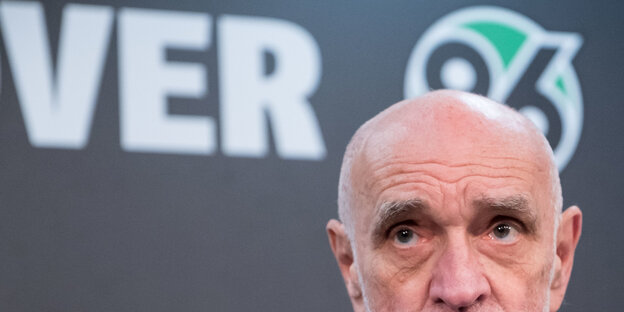 Martin Kind von der Nase aufwärts im Bild, dahinter ein Teil des Logos von Hannover 95 Martin Kind von der Nase aufwärts im Bild, dahinter ein Teil des Logos von Hannover 95