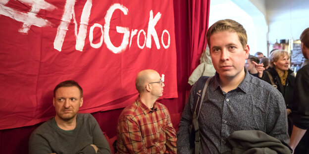 Kevin Kühnert mit einer Jacke über dem Arm, hinter ihm ein rotes Transparent mit der Aufschrift „#NoGroko“ Kevin Kühnert mit einer Jacke über dem Arm, hinter ihm ein rotes Transparent mit der Aufschrift „#NoGroko“