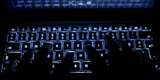 Finger tippen auf einer leuchtenden Tastatur Finger tippen auf einer leuchtenden Tastatur