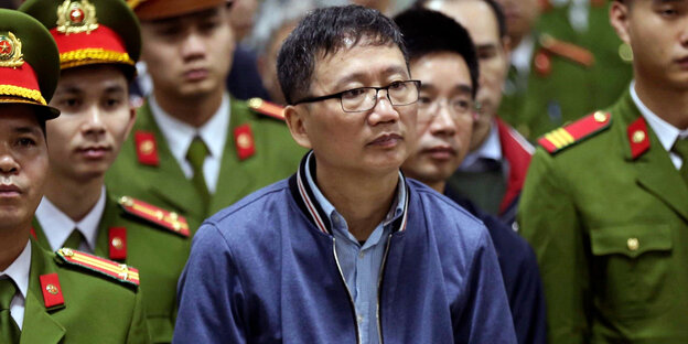 Trinh Xuan Thanh zwischen uniformierten Männern Trinh Xuan Thanh zwischen uniformierten Männern