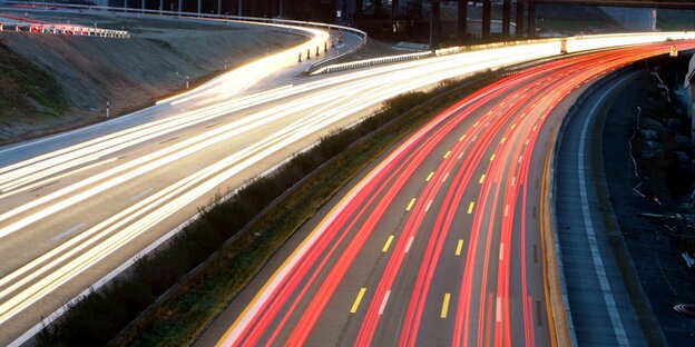 Die Scheinwerfer von Autos auf der Autobahn zerfließen zu roten und weißen Linien Die Scheinwerfer von Autos auf der Autobahn zerfließen zu roten und weißen Linien