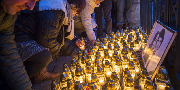 In Bratislava in der Slowakei stellen Menschen zum Gedenken an den ermordeten Journalisten und seine Freundin Kerzen vor ein Foto der beiden In Bratislava in der Slowakei stellen Menschen zum Gedenken an den ermordeten Journalisten und seine Freundin Kerzen vor ein Foto der beiden