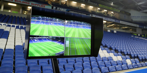 Mehrere Videobildschirme vor einer leeren Zuschauertribühne Mehrere Videobildschirme vor einer leeren Zuschauertribühne