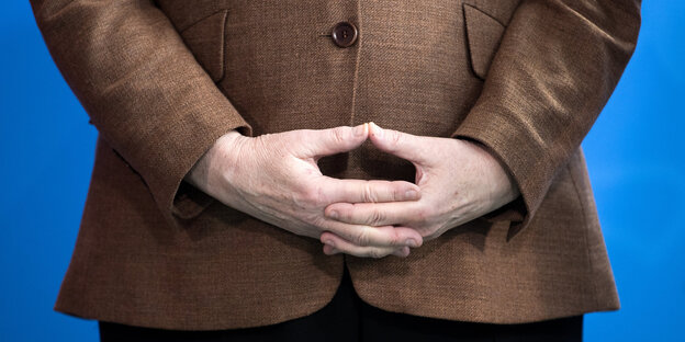 Eine Frau faltet ihre Finger vor ihrem Bauch