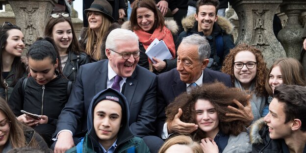 Zwei Politiker und Kinder posieren. Ein Politiker fasst einem Kind in die Haare. Die Politiker lachen Zwei Politiker und Kinder posieren. Ein Politiker fasst einem Kind in die Haare. Die Politiker lachen