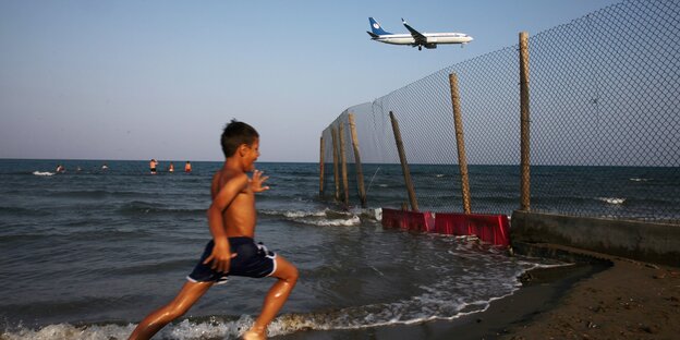 Leute am Strand, darüber ein Flugzeug Leute am Strand, darüber ein Flugzeug