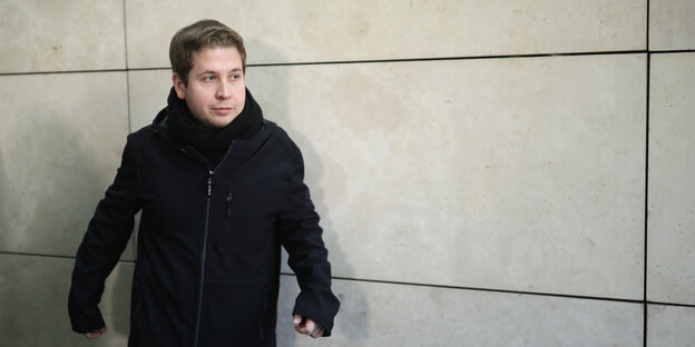 Kevin Kühnert mit schwarzer Jacke und Schal steht an einer Wand gelehnt Kevin Kühnert mit schwarzer Jacke und Schal steht an einer Wand gelehnt