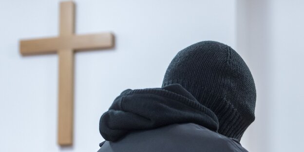 Vermummter Priester vor Holzkreuz Vermummter Priester vor Holzkreuz
